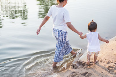 Mother and daughter walking on the beach.