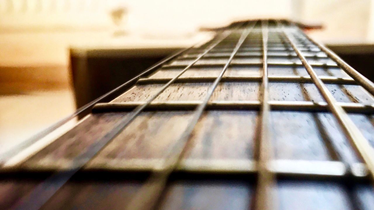 CLOSE-UP OF GUITAR AGAINST THE WALL