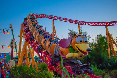 Low angle view of carousel in amusement park against sky