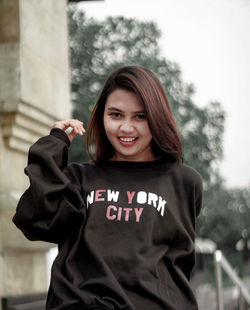 Portrait of smiling young woman standing outdoors