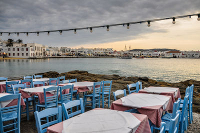 High angle view of chairs and tables by sea at sunset