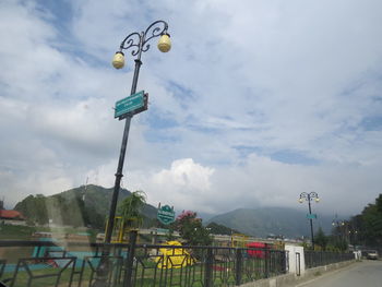 Low angle view of street light against cloudy sky