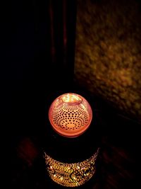 Low angle view of illuminated light bulb on wall