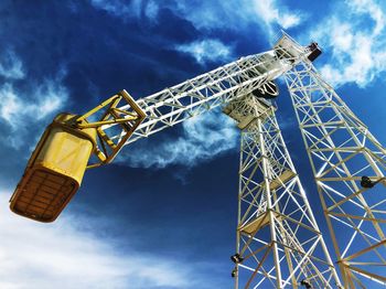 Low angle view of crane against sky