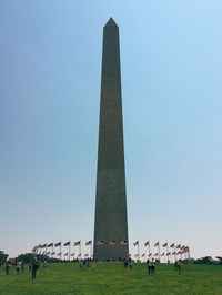 People by washington monument against clear sky