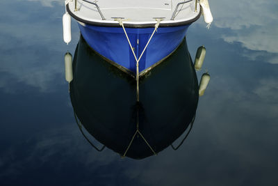 Close-up of boat moored in sea against sky