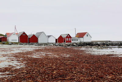 Houses on beach by sea against clear sky