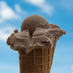Close-up of ice cream cone against sky
