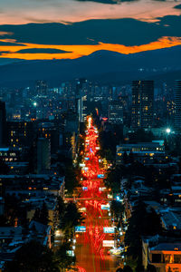 High angle view of illuminated city at sunset