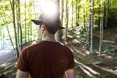 Backlight of hiker with black hat walking through a mediterranean forest