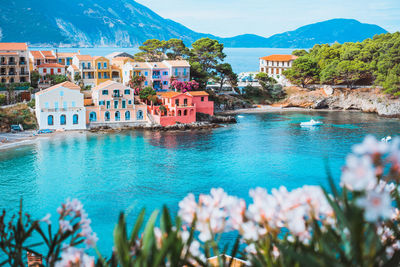 Scenic view of buildings by sea against sky