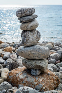 Stack of pebbles on beach against sky