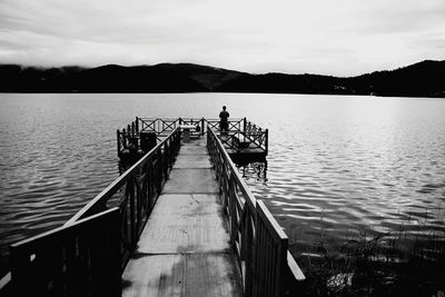 Pier over lake against sky