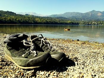 High angle view of shoes by lake against mountain