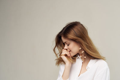 Portrait of beautiful young woman against white background