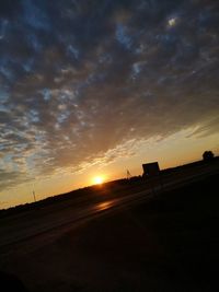 Scenic view of silhouette field against sky during sunset