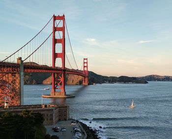 Golden gate bridge over river against sky in city