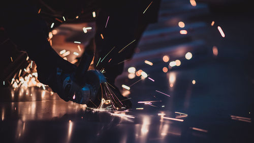 Blurred image of man holding illuminated christmas lights