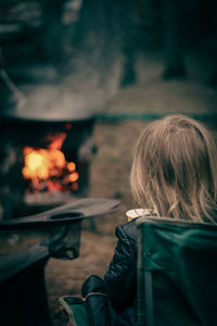 Rear view of woman sitting on fire