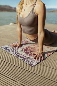 Sportswoman practicing urdhva mukha svanasana during sunny day