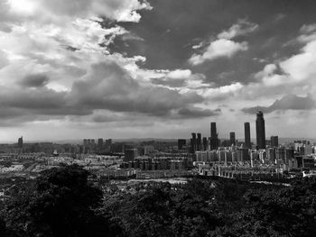 View of cityscape against cloudy sky