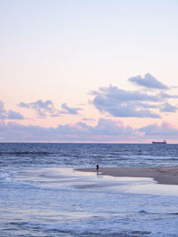 Silhouette person on beach against sky during sunset