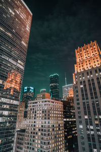 Low angle view of illuminated buildings against sky at night