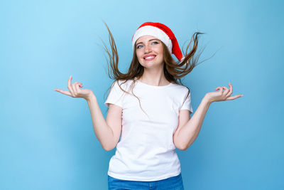 Young woman smiling against blue background