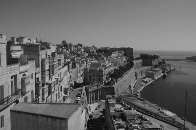 High angle view of buildings and sea against clear sky