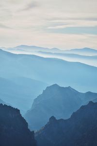 Scenic view of mountains against cloudy sky