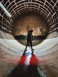 Rear view of man walking in tunnel