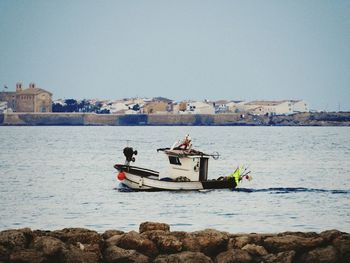 Boat sailing in sea against clear sky