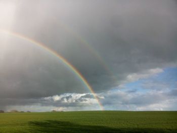 Scenic view of rainbow over landscape against sky