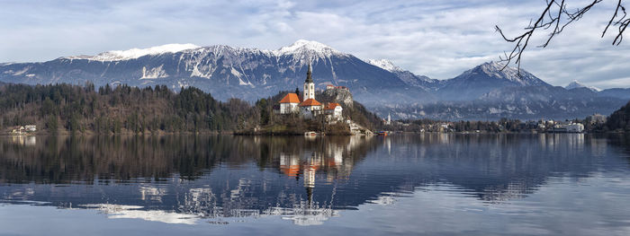 Scenic view of lake by buildings against sky