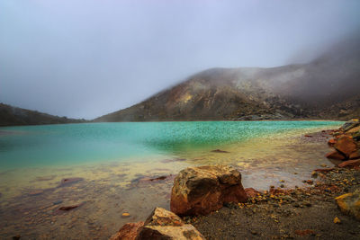 Scenic view of lake against cloudy sky