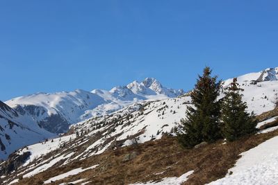 Scenic view of snowcapped mountains against clear blue sky