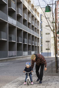 Father teaching daughter to cycle