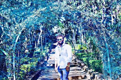 Full length portrait of young man standing in forest