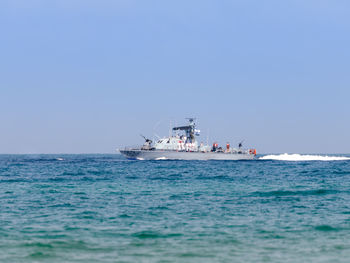 Boat sailing in sea against clear blue sky