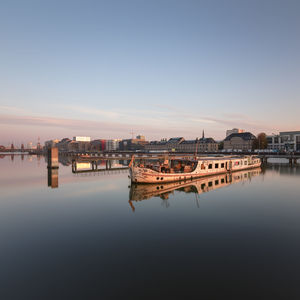 Reflection of buildings in river against sky