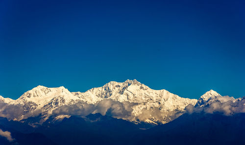 Scenic view of snowcapped mountains against clear blue sky