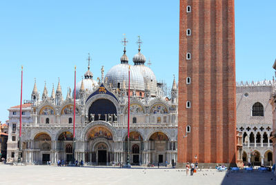 Group of people in front of building against clear sky