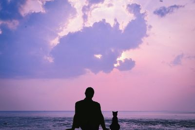 Rear view of man looking at sea against sky