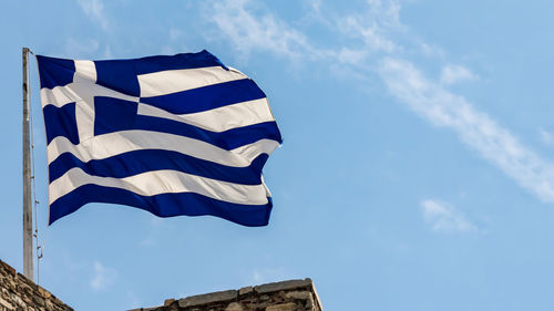 Low angle view of flag against blue sky