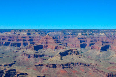 Aerial view of rock formations against blue sky