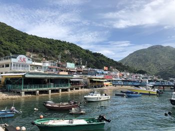 Boats moored at harbor against sky