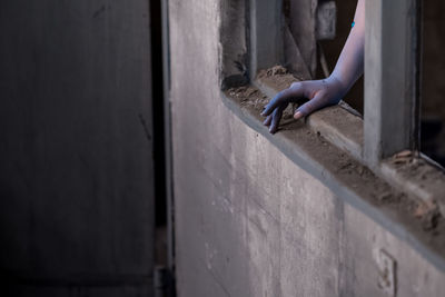 Person holding umbrella against wall