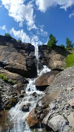 Scenic view of waterfall in forest against sky