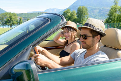 Couple traveling in convertible car