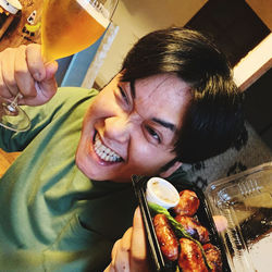 Portrait of smiling young woman holding food